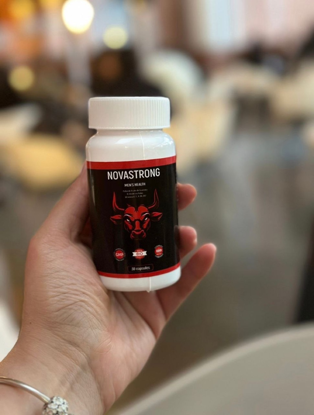 Frasco NovaStrong sostenido en una mano con la etiqueta visible